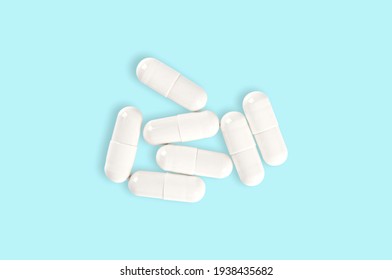 Top view medical capsule pills on blue background.