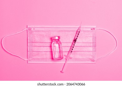 Top View Medical Composition Of Syringe With Medicine, Antibiotic Vial And Protective Mask On Minimal Pink Background. Cosmetology And Beauty Industry