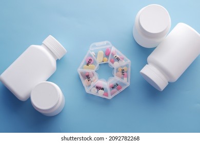 Top View Of Medical Pills And Pill Box On Blue 