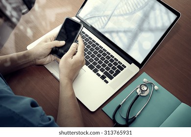 Top View Of Medicine Doctor Hand Working With Modern Computer And Smart Phone With Social Media Network On Wooden Desk As Medical Concept