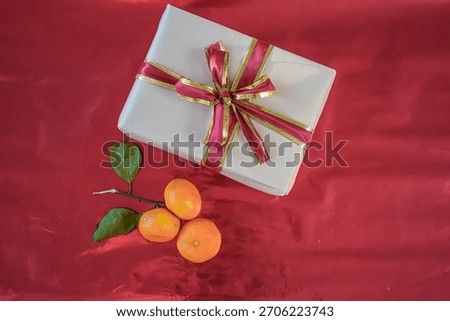 Top View Medium Shot of Beige Gift Box with Tangerines on Red Background