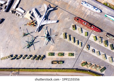 Top View Of The Military Base. Tanks, Self-propelled Howitzers, Rocket Launchers, Helicopters And Aircraft