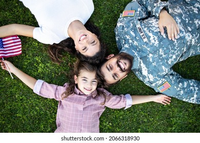 Top View Of Military Family Lying On The Grass Spending Time Together With Soldier Coming Home.