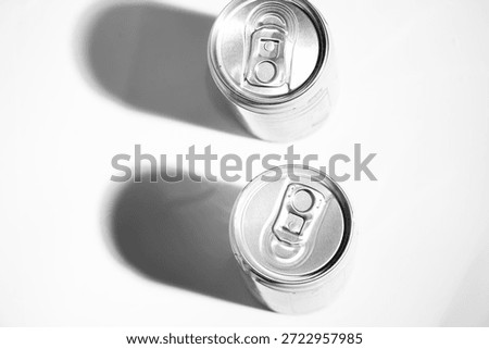 Top view of an milk can with a pull-tab lid with shadow, casting a shadow on a light gray, textured background. The aluminum can gleams under soft studio lighting. 
