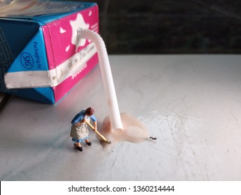 Top View Mini Figure Toy Woman Cleaning Spilled UHT Chocolate Milk At Floor, Drink By One Small Ant
