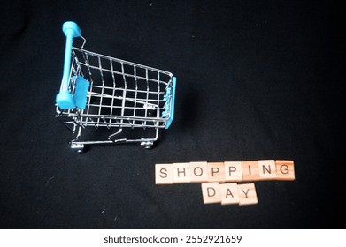 Top view Miniature shopping cart, dollar bills and "SHOPPING DAY" writing on dark background, National shopping day concept. Online shopping concept - Powered by Shutterstock