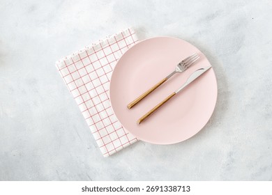 Top view of minimalistic table setting with empty plate, cutlery and cutlery on white gray background, flat lay.