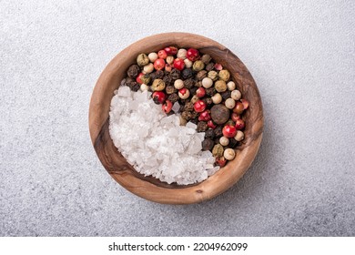 Top view of mix peppercorns and sea salt in wooden bowl for spicy and aromatic food on grey concrete background - Powered by Shutterstock