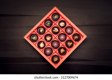 Top view of mixed Belgian chocolates in a red box. Luxury handmade delicious praline for gift. Concept of World Chocolate Day.
