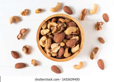 Top View Of Mixed Nuts In A Wooden Bowl On White Background