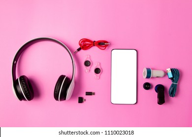 top view mobile device with mobile blank space for text,accessories. micro USB Adapter, macro lens and headset on pink background