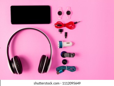 top view mobile device with mobile blank space for text,accessories. micro USB Adapter, macro lens and headset on pink background