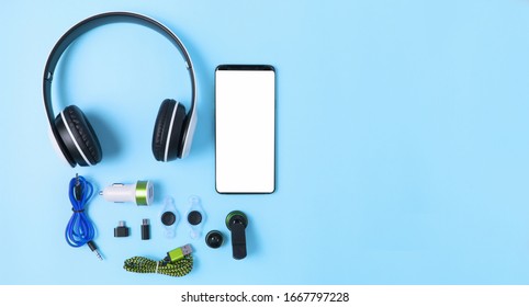 top view mobile device with mobile blank space for text,accessories. micro USB Adapter, macro lens and headset on blue background