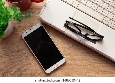 Top View Of Mobile Phone On Desktop