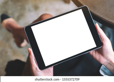 Top View Mockup Image Of A Woman Holding Black Tablet With White Blank Screen 