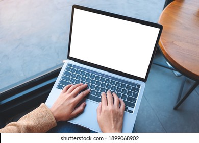 Top view mockup image of a woman using and typing on laptop computer with blank white desktop screen