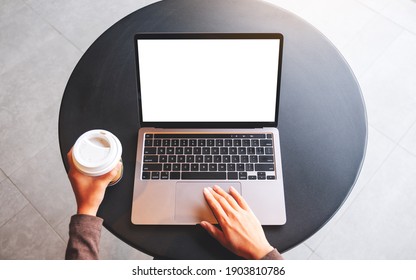 Top View Mockup Image Of A Woman Using And Touching On Laptop Touchpad With Blank White Desktop Screen While Drinking Coffee