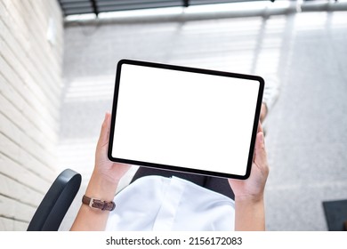 Top view mockup image of a woman holding digital tablet with blank white desktop screen in office - Powered by Shutterstock