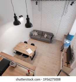 Top View Of Modern Living Room Open To Kitchen In Small Loft Apartment With White Brick On The Wall