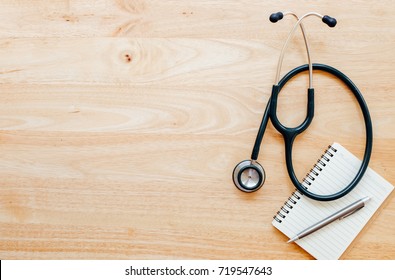 Top View Of Modern, Sterile Doctors Office Desk. Medical Accessories On A Wooden Table Background With Copy Space Around Products. Photo Taken From Above.