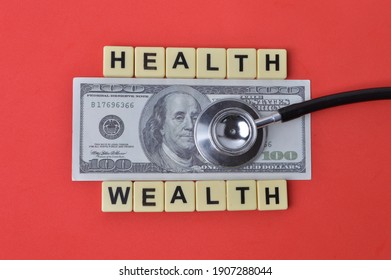 Top View Of Money Banknote, Stethoscope And Scrabble Letters With Text HEALTH And WEALTH Over Red Background. 