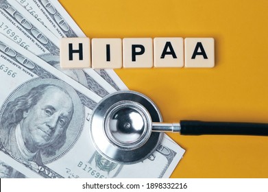 Top View Of Money Banknotes, Stethoscope And Scrabble Letters With Text HIPAA Stands For Health Insurance Portability And Accountability Act.