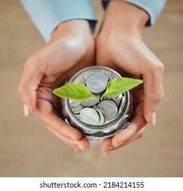 Top View Of Money, Coins And Cash In A Jar For Savings, Budget And Future Needs. Closeup Of The Hands Of A Person Holding A Jug Growing With Funds For Spending, Payment Or Donation From Above