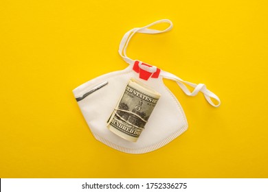 Top View Of Money Roll And Safety Mask On Yellow Background