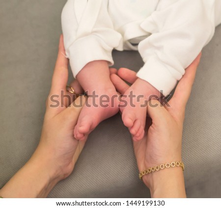 Top view of mother hands holding  newborn baby  soft feet 