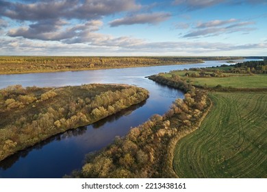 Top View Of The Mouth Of Two Rivers On A Background Of Green Autumn Fields And Yellow Trees And Sky. Aerial Photo Of Landscape