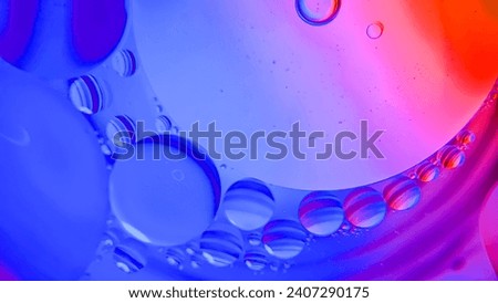 Top view of movement of oil bubbles in liquid. Fantastic colorful bubble structure. Colorful artistic image of oil droplets floating on water. Macro shot of water oil emulsion over colored background