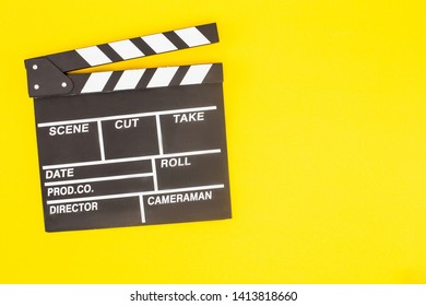 top view of movie clapper board on bright yellow background with copy space - Shutterstock ID 1413818660