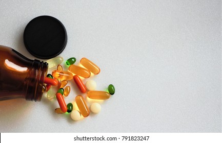 Top view multi vitamins and supplements with brown bottle on white background with copy space. 