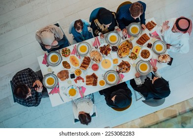 Top view of Muslim family having Iftar dinner drinking water to break feast. Eating traditional food during Ramadan feasting month at home. The Islamic Halal Eating and Drinking in modern home 