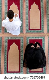 Top View Of Muslim Man And Woman Praying In Mosque