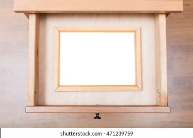 top view of narrow picture frame with cut out canvas in open drawer of nightstand - Shutterstock ID 471239759