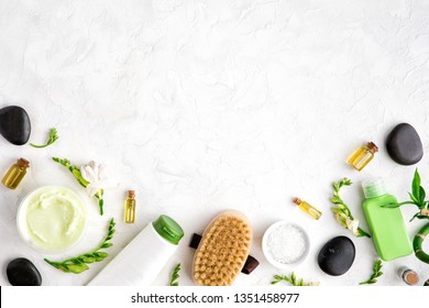 Top View Of Natural Skincare And Spa Cosmetic Products On White Marble Table, Flat Lay. Frame Of Cream, Oil, Sea Bath Salt, Massage Brush, Bamboo And Flower Buds. Beauty Flatlay Concept