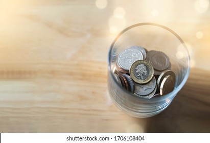 Top view New one pound British sterling coin and penny and in glass bottle on wooden table, Concept financial business investment with Copy space for your text