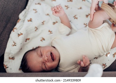 Top View Of A Newborn Baby Lying Down While The Mother Hands Put Clothes On