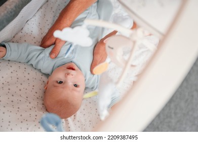 Top View Of Newborn Baby That Is Lying Down In The Cradle.