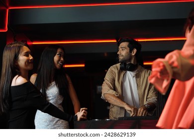 Top view of a nightclub, two young friends, Asian girl and Caucasian girl drinking wine and having fun dancing in front of the bar counter in a nightclub. - Powered by Shutterstock