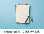 Top view of notebook and fountain pen on blue background