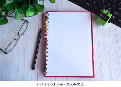 Top view of notebook with tally counter clicker, glasses, pen, keyboard - Shutterstock ID 2100463105