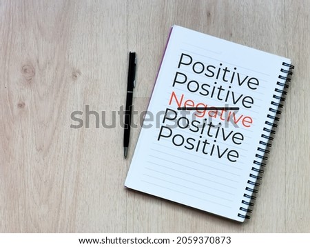 Top view notebook with text positive and negative with a pen.