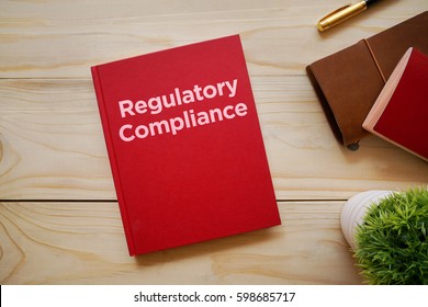 Top View Of Notebook With Word Regulatory Compliance