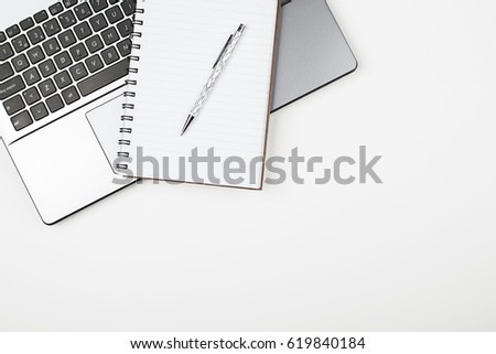 Top view of notepad and pen on laptop keyboard. Horizontal shoot.