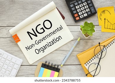 top view of notepad with text. orange paper clip NGO Non-Governmental Organization
