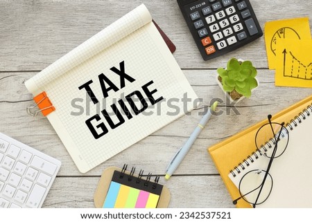 top view of notepad with text. orange paper clip Income Taxes