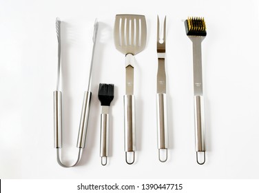 Top View Object Set Of BBQ Equipment Stainless Steel As Tongs, Carving Fork, Spatula. Isolated On A White Background