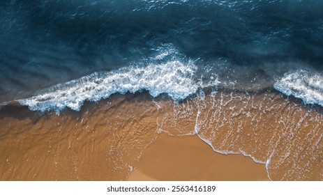 Vista superior do azul do oceano e da areia da praia marrom como fundo para o projeto do modelo do banner da página da web. Ondas quebrando na areia suave. Água calma e clara